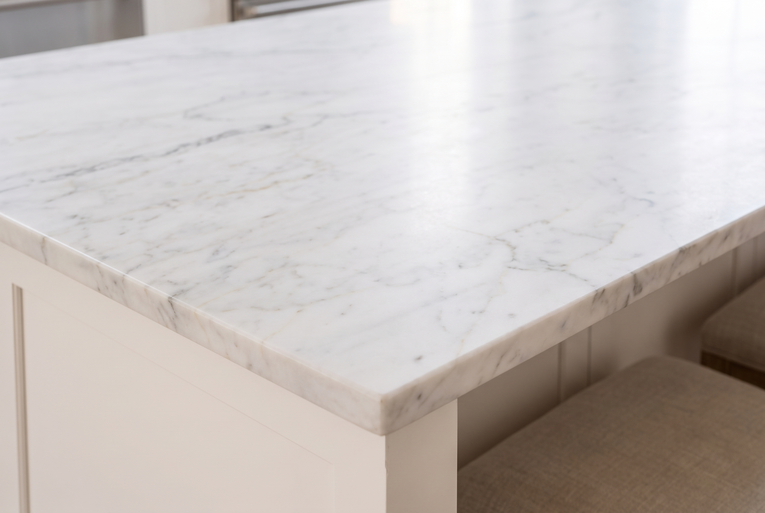 Close detail of a honed marble edge with a nearly invisible protective-film seam.