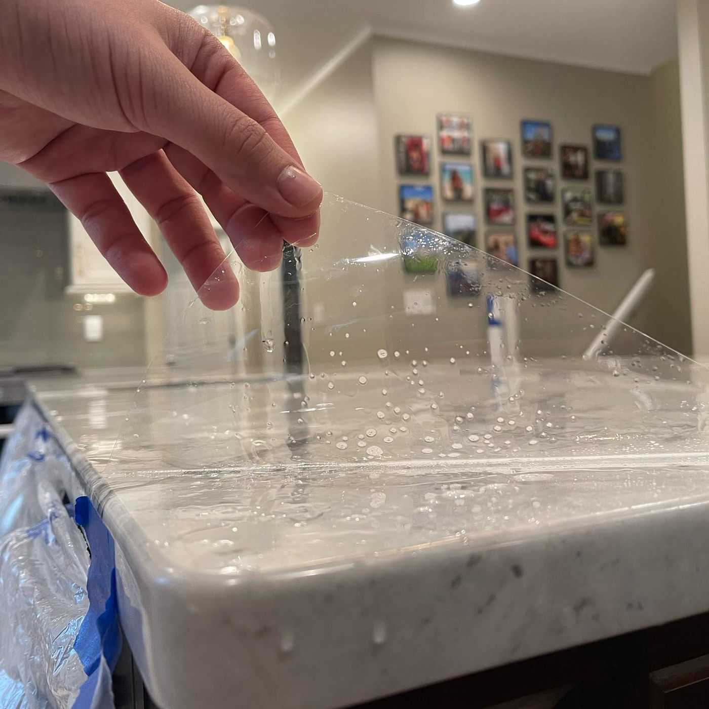 The film, partially lifted. Water beads on top. Grey-veined Marble with StoneGuard Clear film in Greenwich, CT